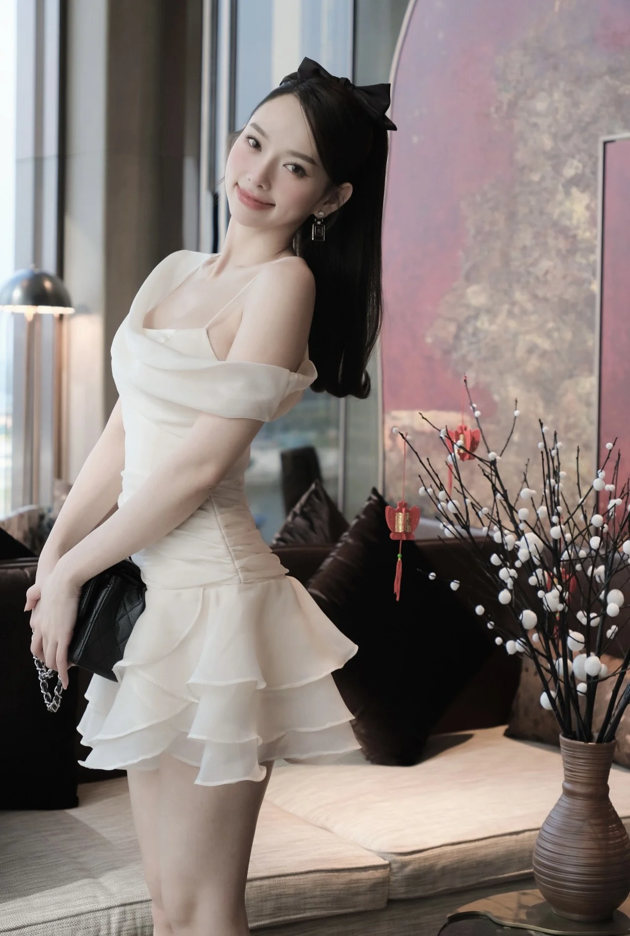 Model wearing a cream off-shoulder ruffled outfit