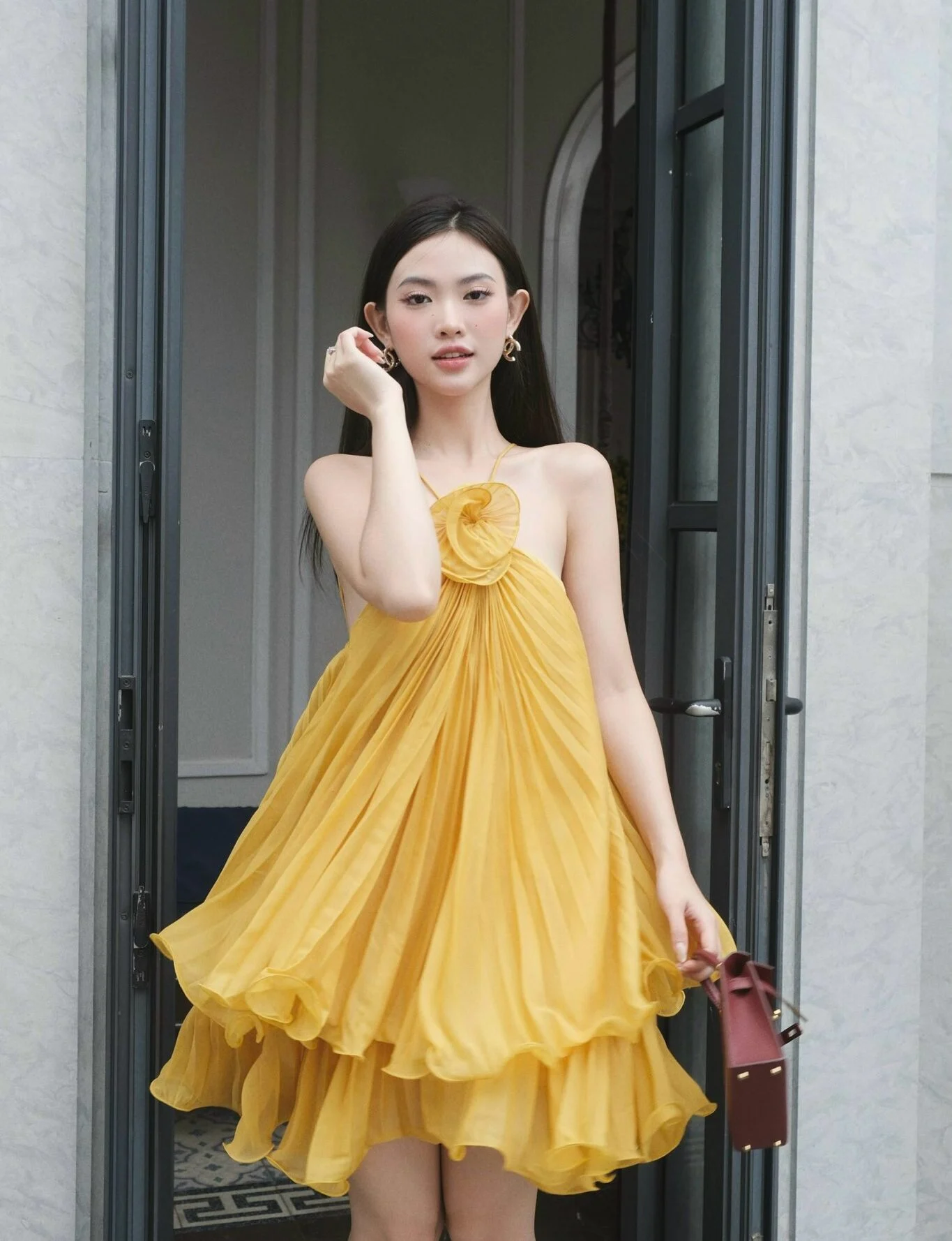 Model wearing a yellow halter-neck ruffled dress